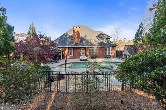 back of house featuring a patio area and a swimming pool with hot tub