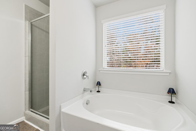 bathroom featuring a stall shower and a bath