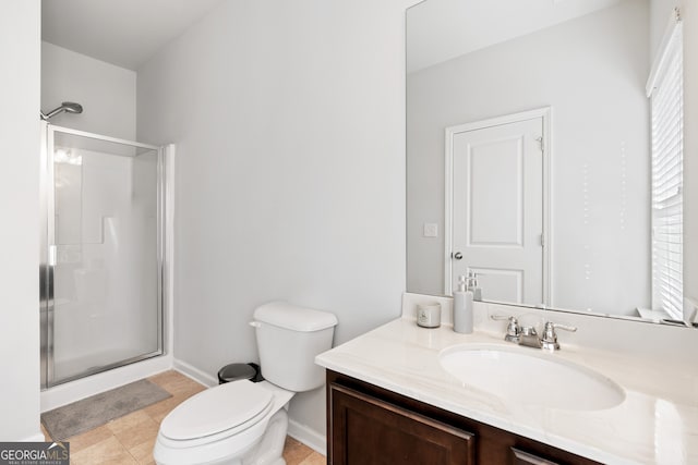 bathroom with toilet, a shower stall, vanity, and baseboards