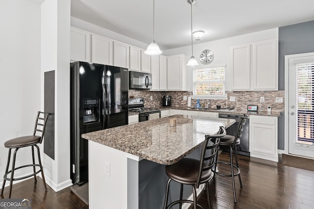 kitchen featuring black appliances, a center island, white cabinetry, and pendant lighting