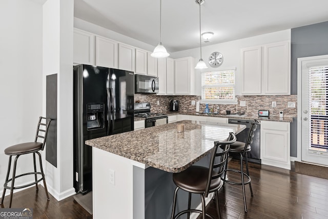 4192 Integrity Way, Powder Springs, GA 30127 - kitchen featuring black appliances, a breakfast bar area, a center island, tasteful backsplash, and light stone counters