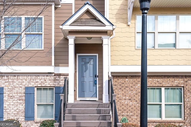 view of exterior entry featuring brick siding