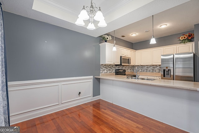 kitchen featuring sink, stainless steel appliances, hardwood / wood-style floors, decorative light fixtures, and decorative backsplash