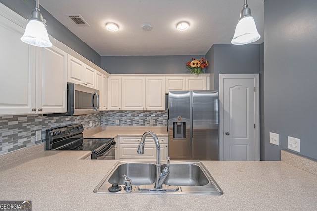 kitchen with sink, white cabinets, stainless steel appliances, and decorative light fixtures