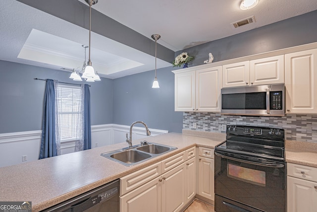 kitchen featuring sink, hanging light fixtures, a raised ceiling, decorative backsplash, and appliances with stainless steel finishes