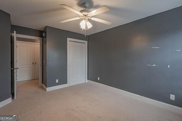 unfurnished bedroom with ceiling fan, a closet, and light colored carpet