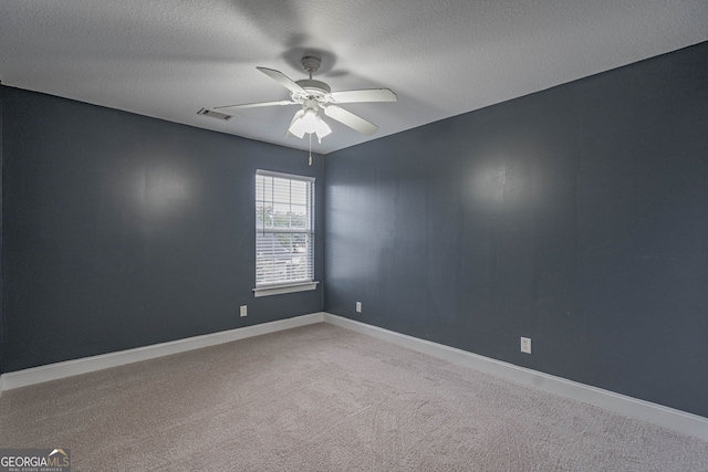 unfurnished room with ceiling fan, carpet, and a textured ceiling