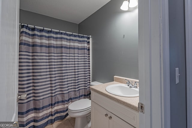 bathroom with tile patterned flooring, vanity, toilet, and curtained shower