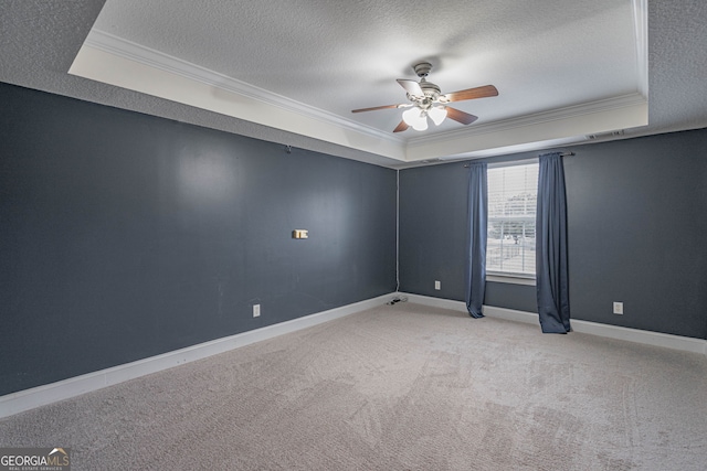 unfurnished room with a tray ceiling, crown molding, light colored carpet, and a textured ceiling