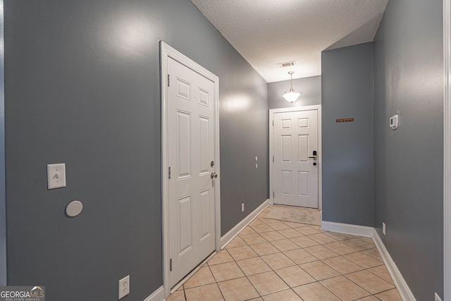 tiled entryway with a textured ceiling