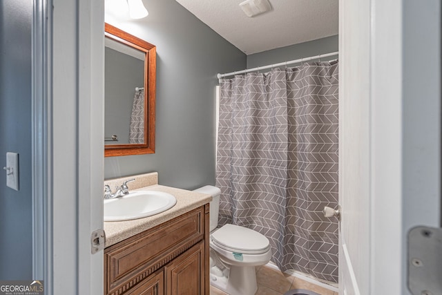 bathroom with a shower with curtain, a textured ceiling, vanity, tile patterned flooring, and toilet