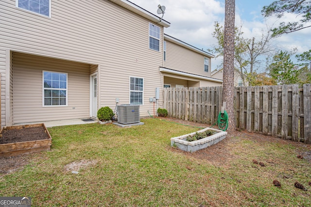 rear view of house featuring a yard and central AC