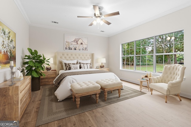 bedroom featuring ceiling fan, wood-type flooring, and crown molding