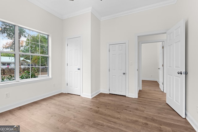 unfurnished bedroom with hardwood / wood-style floors and ornamental molding