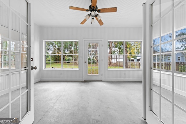 unfurnished sunroom featuring ceiling fan