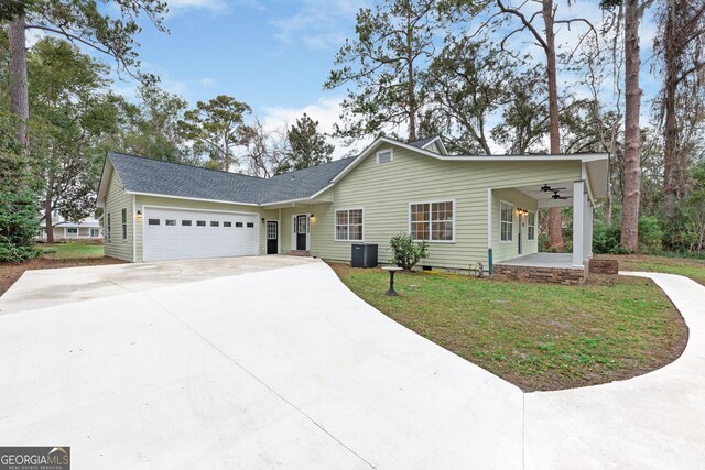 ranch-style house featuring covered porch, a front lawn, ceiling fan, central AC, and a garage