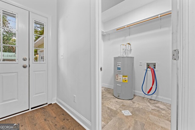 interior space featuring water heater, washer hookup, and light hardwood / wood-style floors