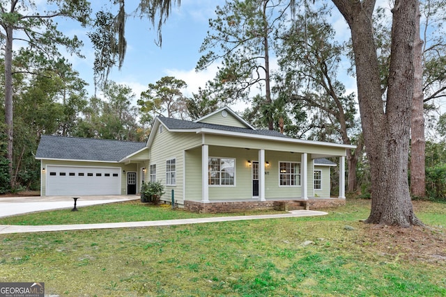 view of front of property featuring covered porch, a front yard, and a garage