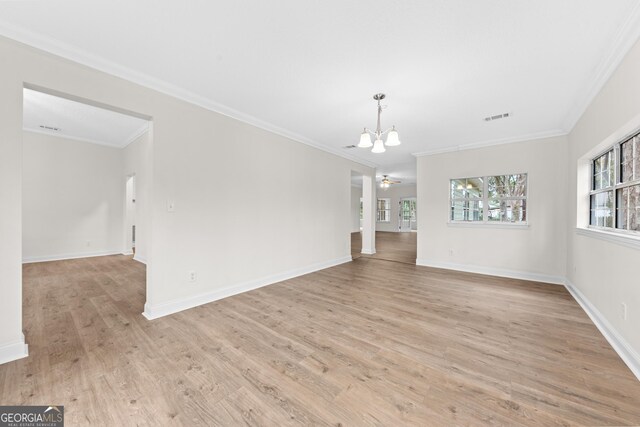 interior space with ornamental molding, ceiling fan with notable chandelier, and light wood-type flooring