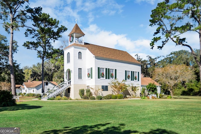 view of front of property featuring a balcony and a front yard