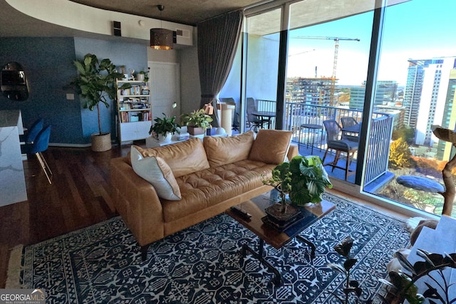 living area with a wall of windows, a view of city, and wood finished floors