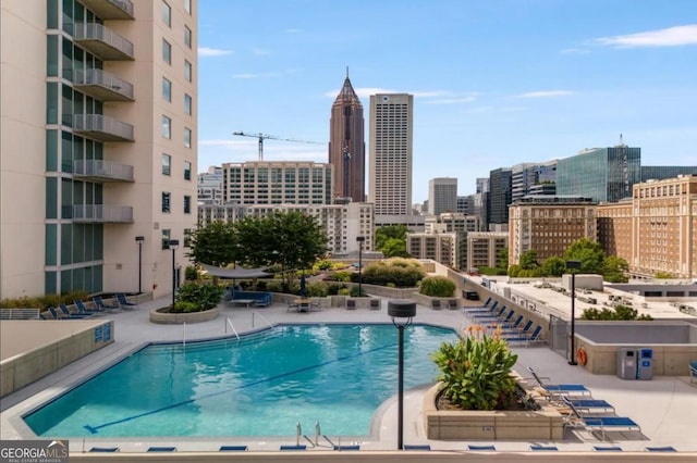 view of pool with a patio area and a city view