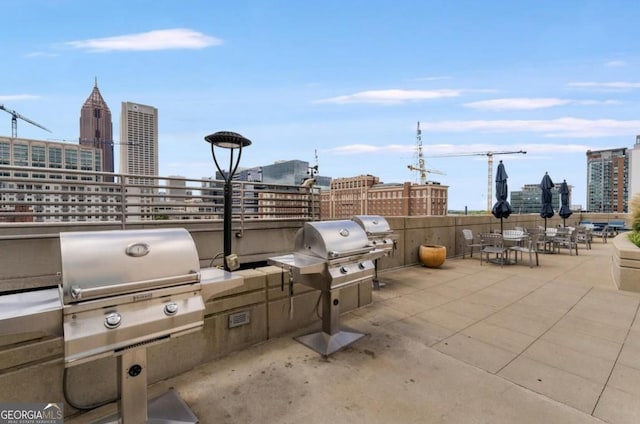 view of patio featuring a view of city, outdoor dining space, grilling area, and area for grilling