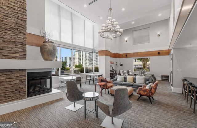 carpeted living room with recessed lighting, a notable chandelier, a high ceiling, a multi sided fireplace, and baseboards