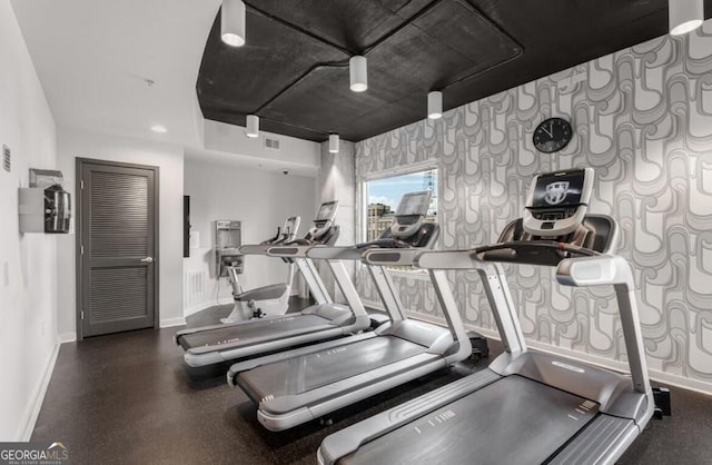 exercise room with wallpapered walls, visible vents, and baseboards