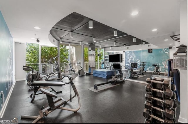 workout area with a wall of windows, recessed lighting, and baseboards