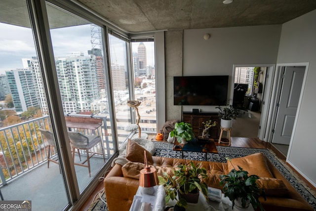 living room featuring a wall of windows and wood finished floors