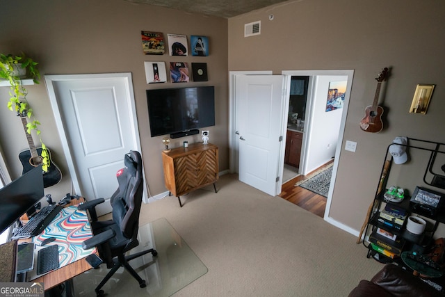 office featuring carpet flooring, visible vents, and baseboards