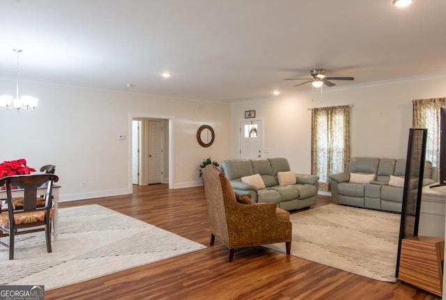 living room featuring hardwood / wood-style flooring, ceiling fan with notable chandelier, and ornamental molding