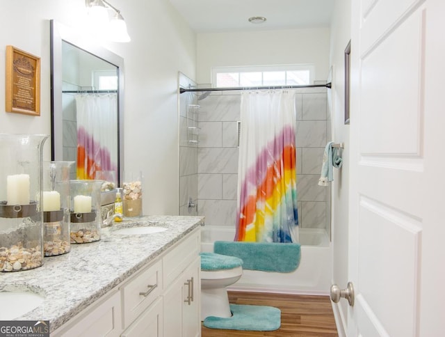 full bathroom with hardwood / wood-style floors, vanity, toilet, and shower / tub combo