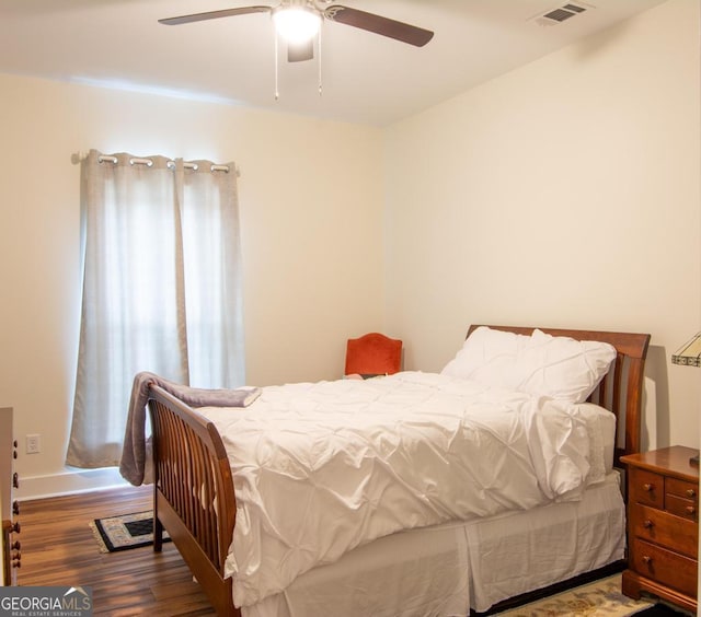 bedroom with ceiling fan and dark wood-type flooring