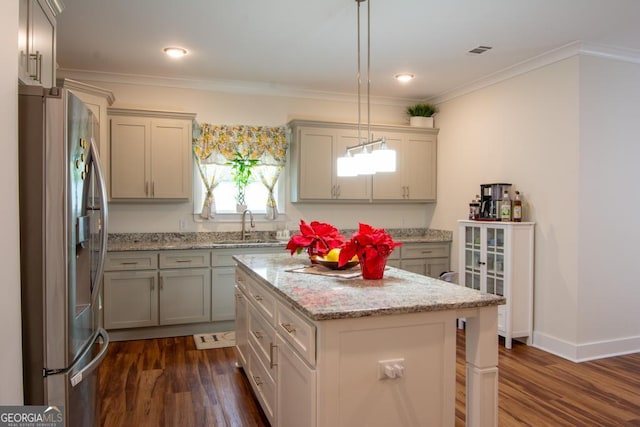 kitchen with sink, hanging light fixtures, dark hardwood / wood-style floors, a kitchen island, and stainless steel refrigerator