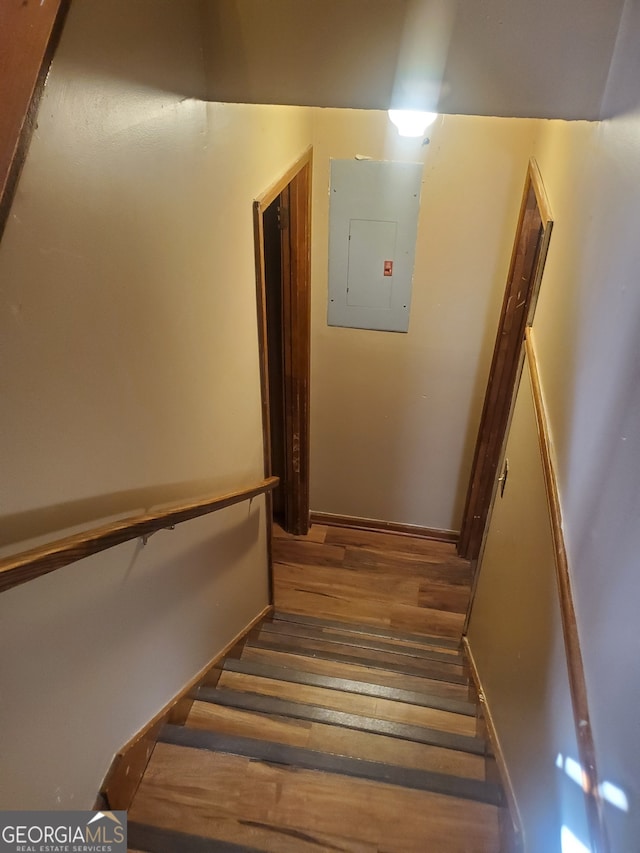 stairway with electric panel and wood-type flooring