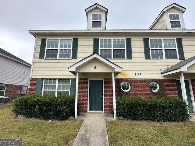 view of front of property with cooling unit and a front lawn