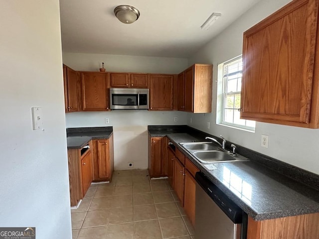 kitchen with sink, light tile patterned floors, and appliances with stainless steel finishes