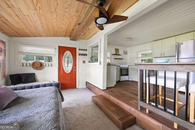 carpeted living room featuring ceiling fan, wooden ceiling, and lofted ceiling