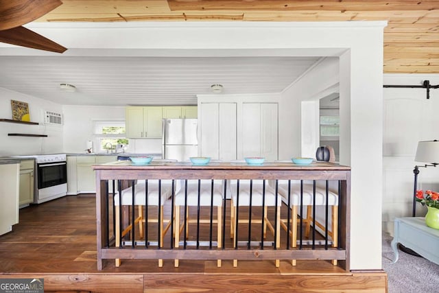 kitchen featuring dark hardwood / wood-style flooring, white appliances, sink, a barn door, and wooden ceiling