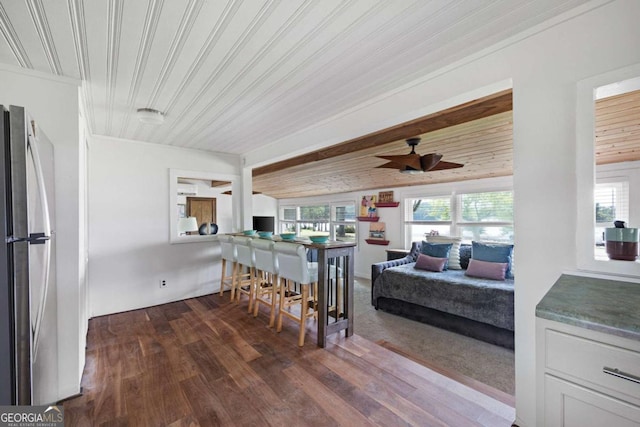 dining space with plenty of natural light, ceiling fan, dark hardwood / wood-style flooring, and wooden ceiling