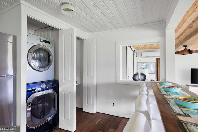 laundry room with a wall mounted air conditioner, stacked washing maching and dryer, dark wood-type flooring, and ornamental molding