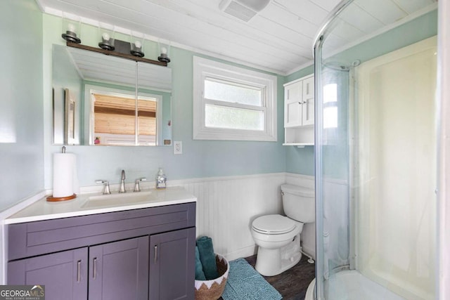 bathroom featuring vanity, a shower, hardwood / wood-style flooring, toilet, and ornamental molding