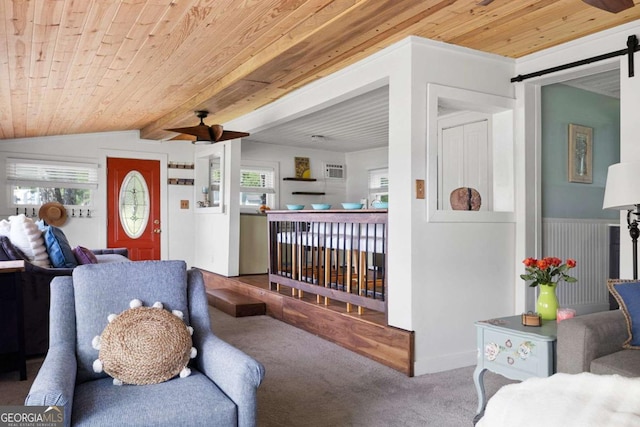 carpeted living room with vaulted ceiling with beams, ceiling fan, wooden ceiling, and a barn door