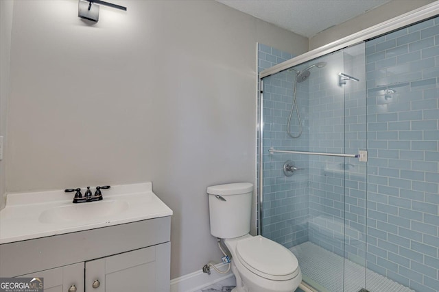 bathroom with toilet, vanity, a textured ceiling, and walk in shower