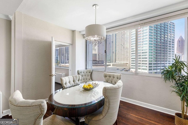 dining area with a notable chandelier, plenty of natural light, and dark wood-type flooring