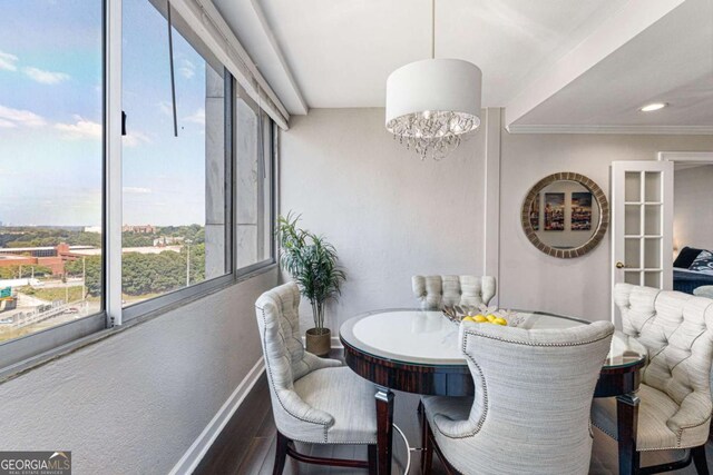 dining area featuring a chandelier, crown molding, and dark wood-type flooring