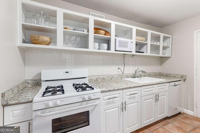 kitchen with white cabinets, decorative backsplash, white appliances, and sink