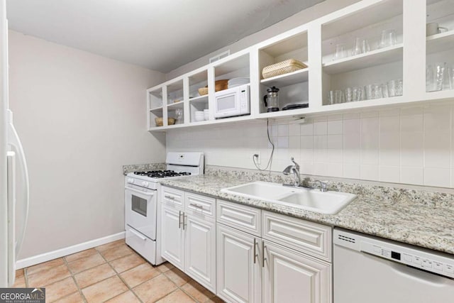 kitchen with white cabinetry, sink, tasteful backsplash, white appliances, and light tile patterned floors